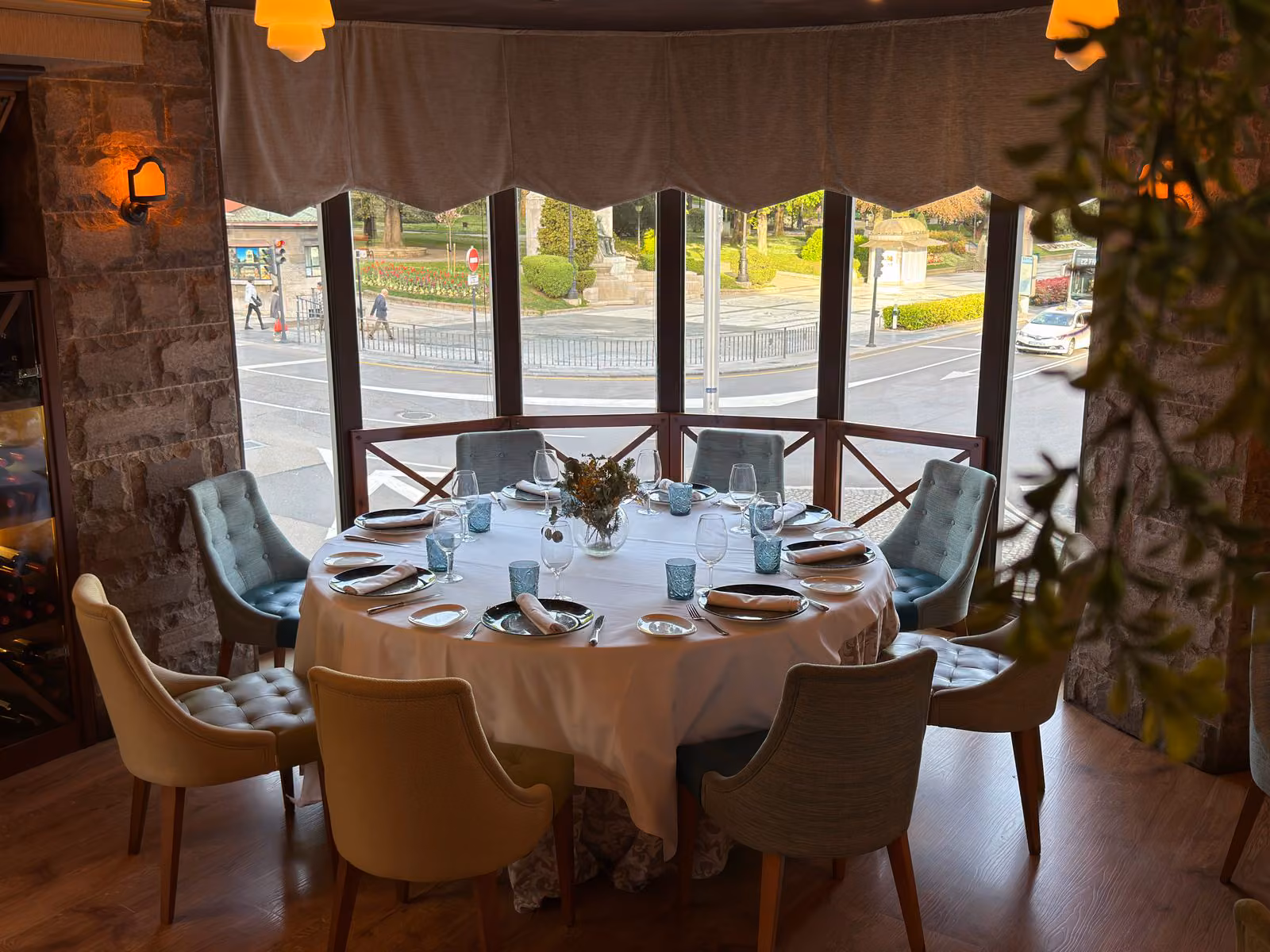 Mesa redonda preparada para grupo con grandes ventanales y vistas al centro de Oviedo desde el restaurante La Corte de Pelayo