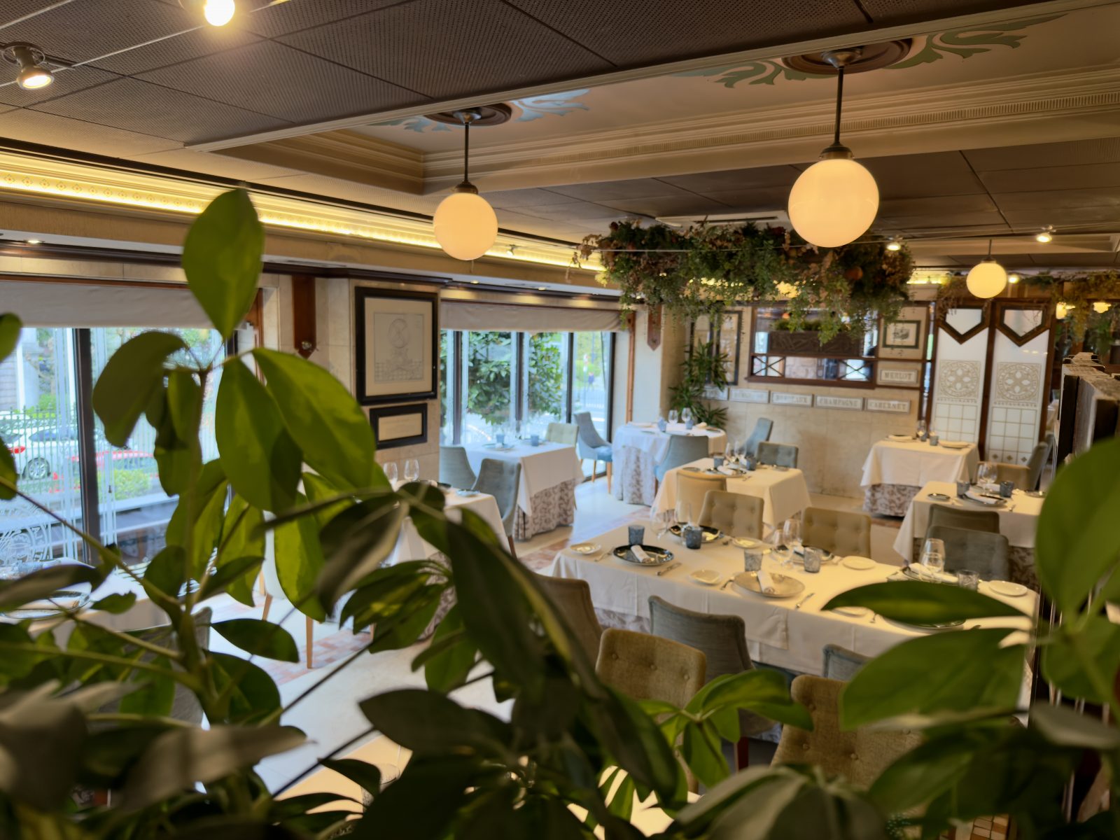 Interior del restaurante La Corte de Pelayo en Oviedo, decoración con plantas y mesas preparadas